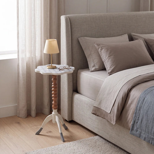 Mesita Ondina en un dormitorio elegante junto a la cama, usada como apoyo decorativo
