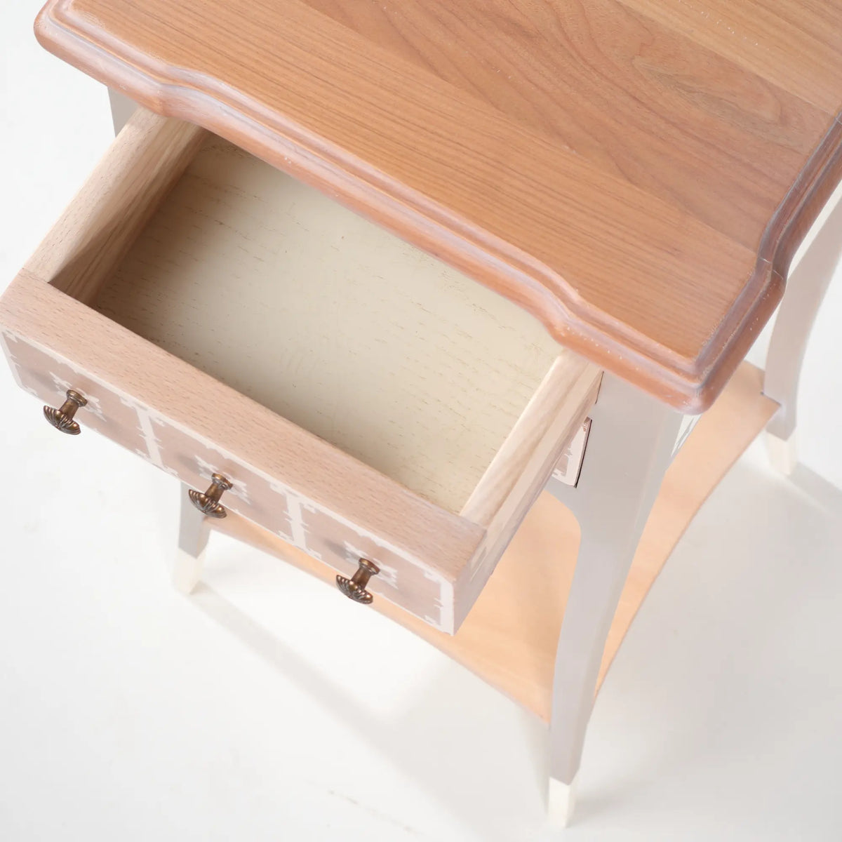 Interior del cajón superior de la mesita Rubic y detalle de la tapa con veta de madera visible.