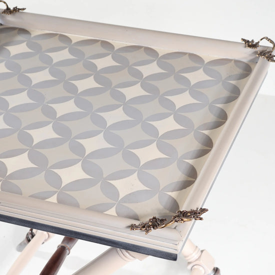 Detalle del tablero decorativo de la mesita Safari con motivos geométricos y adornos en las esquinas.