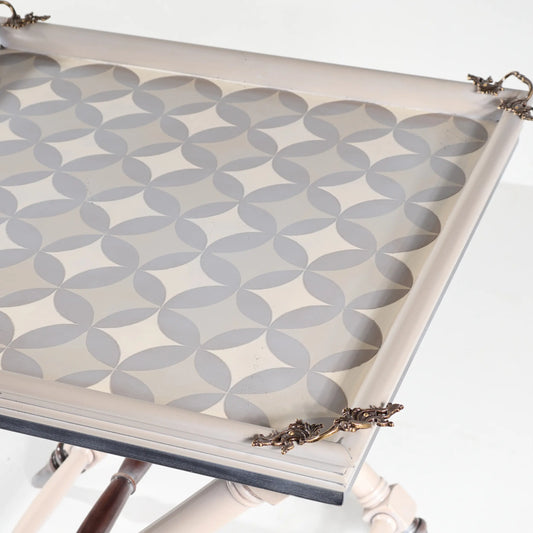 Detalle del tablero decorativo de la mesita Safari con motivos geométricos y adornos en las esquinas.