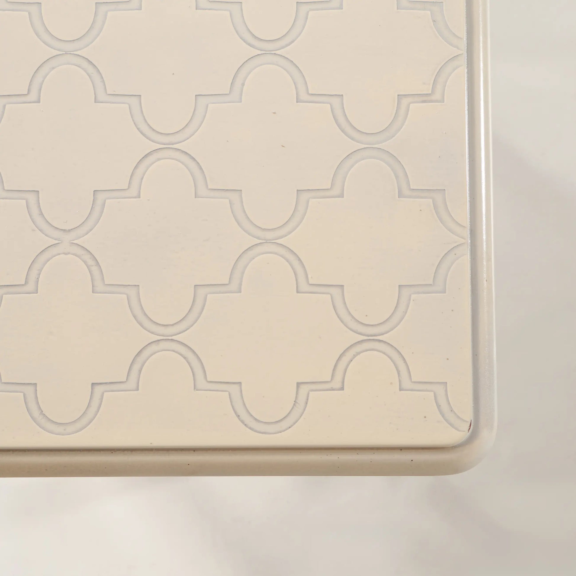 Detalle del sobre intermedio de las Mesitas Tris con dibujo ornamental repetido en crema