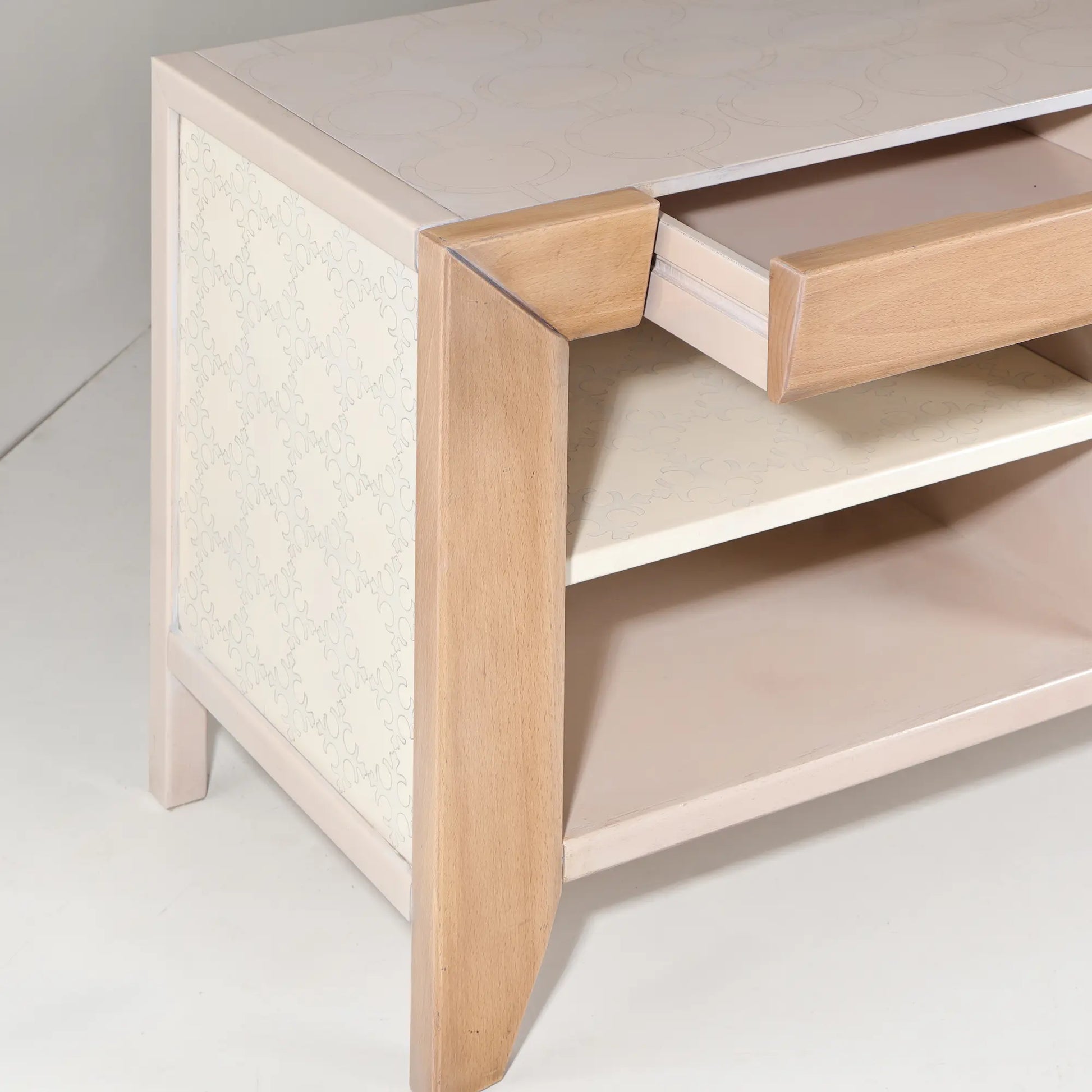 Detalle del tirador en tono dorado sobre el acabado crema del mueble TV Ada.