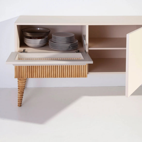 Detalle interior del Mueble de TV Uka con puertas abiertas y compartimentos de almacenaje.