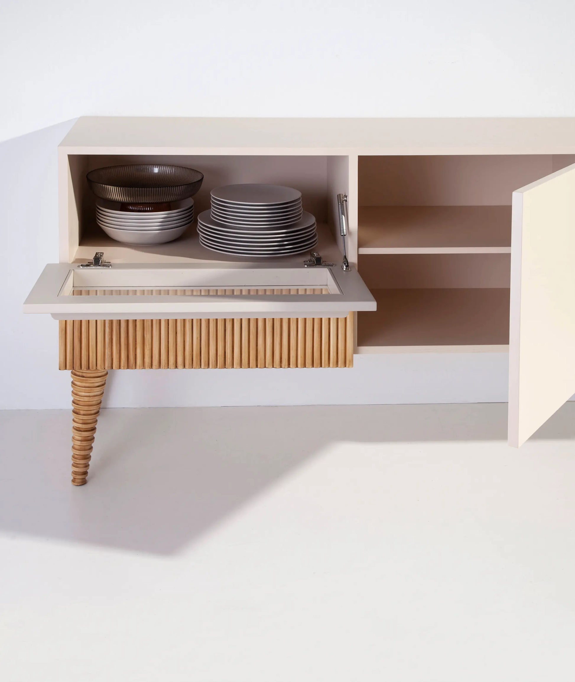 Detalle interior del Mueble de TV Uka con puertas abiertas y compartimentos de almacenaje.