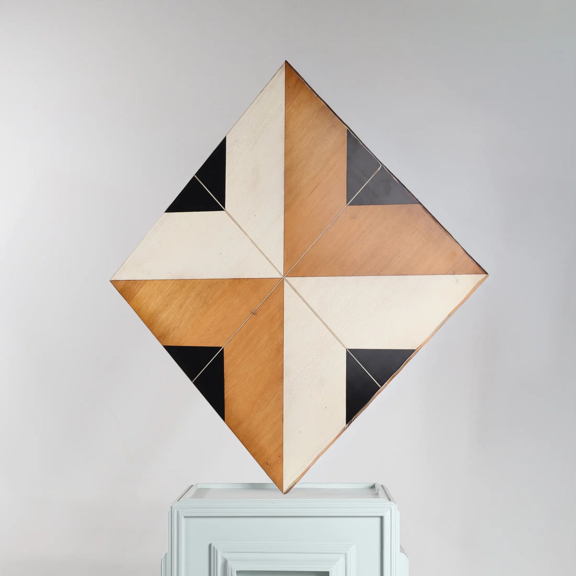 Detalle del Revestimiento 07 con diseño geométrico en tonos madera, blanco roto y negro sobre panel decorativo de pared