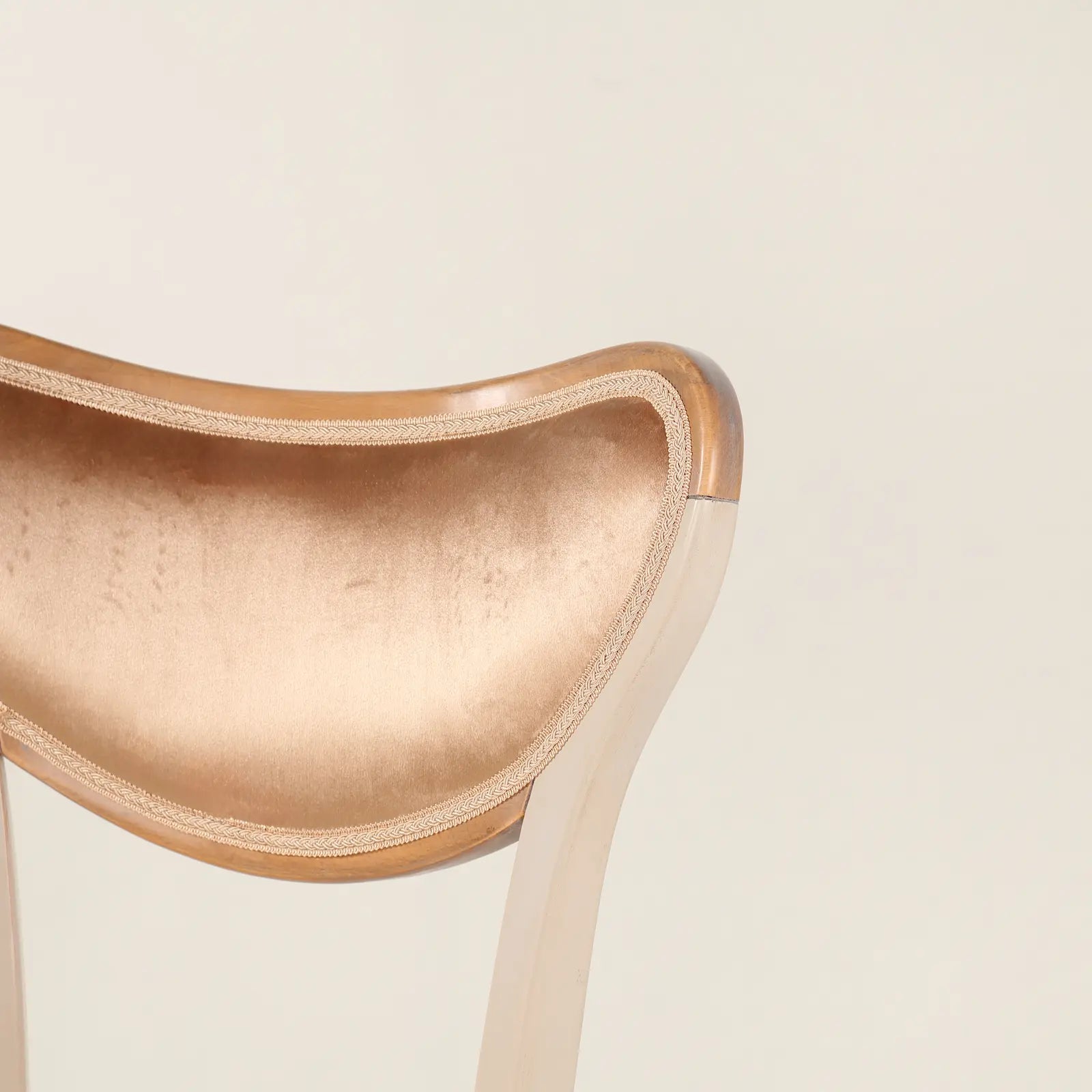 Detalle del respaldo curvo de la Silla Cuore tapizada en color champagne.