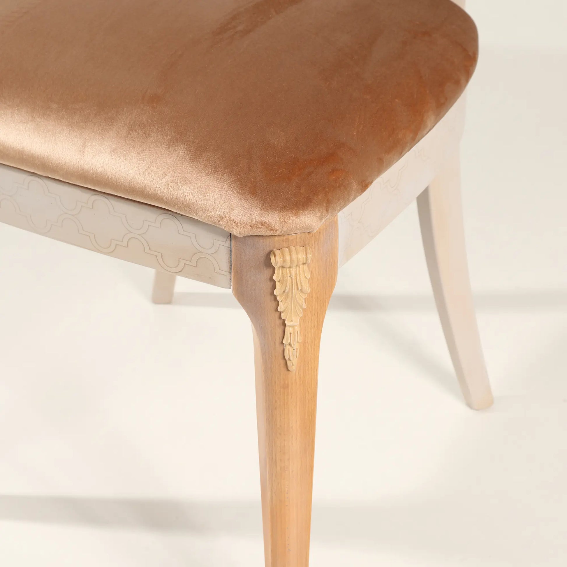 Detalle del asiento tapizado champagne y pata decorativa de la Silla Cuore.