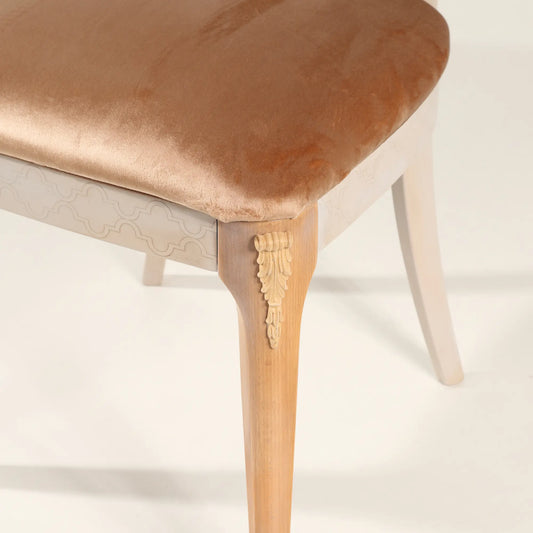Detalle del asiento tapizado champagne y pata decorativa de la Silla Cuore.