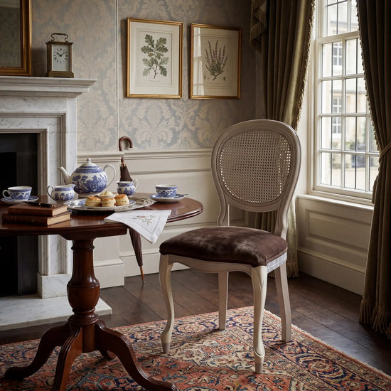 Silla Manila en ambiente clásico con mesa auxiliar y decoración elegante.
