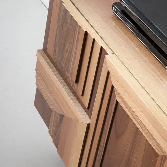 Detalle del mueble TV Totem Suspendido con relieves geométricos tallados y acabados artesanales en madera.