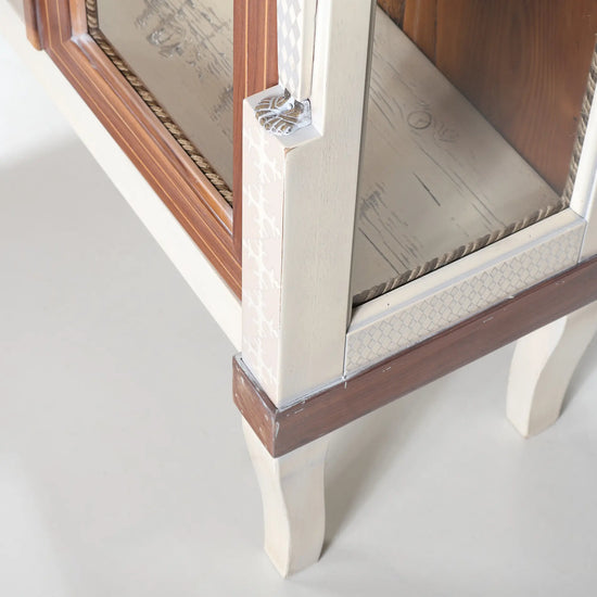 Detalle inferior de la vitrina Caribela con motivos geométricos y pata estilizada.