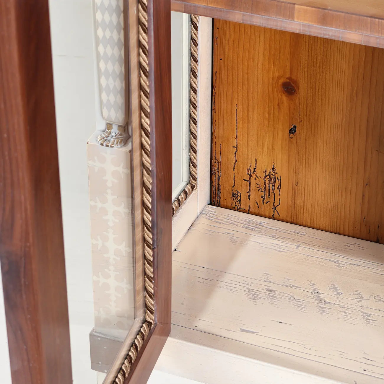 Detalle interior de la vitrina Caribela con puerta acristalada y acabado de apariencia envejecida.
