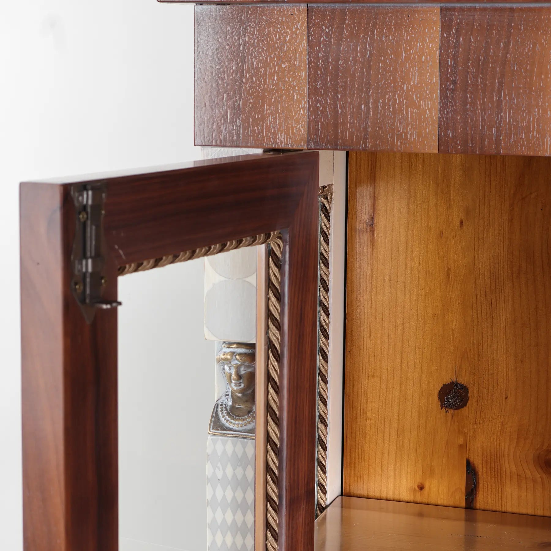 Detalle interior de la vitrina Caribela con puerta acristalada y acabado de apariencia envejecida.