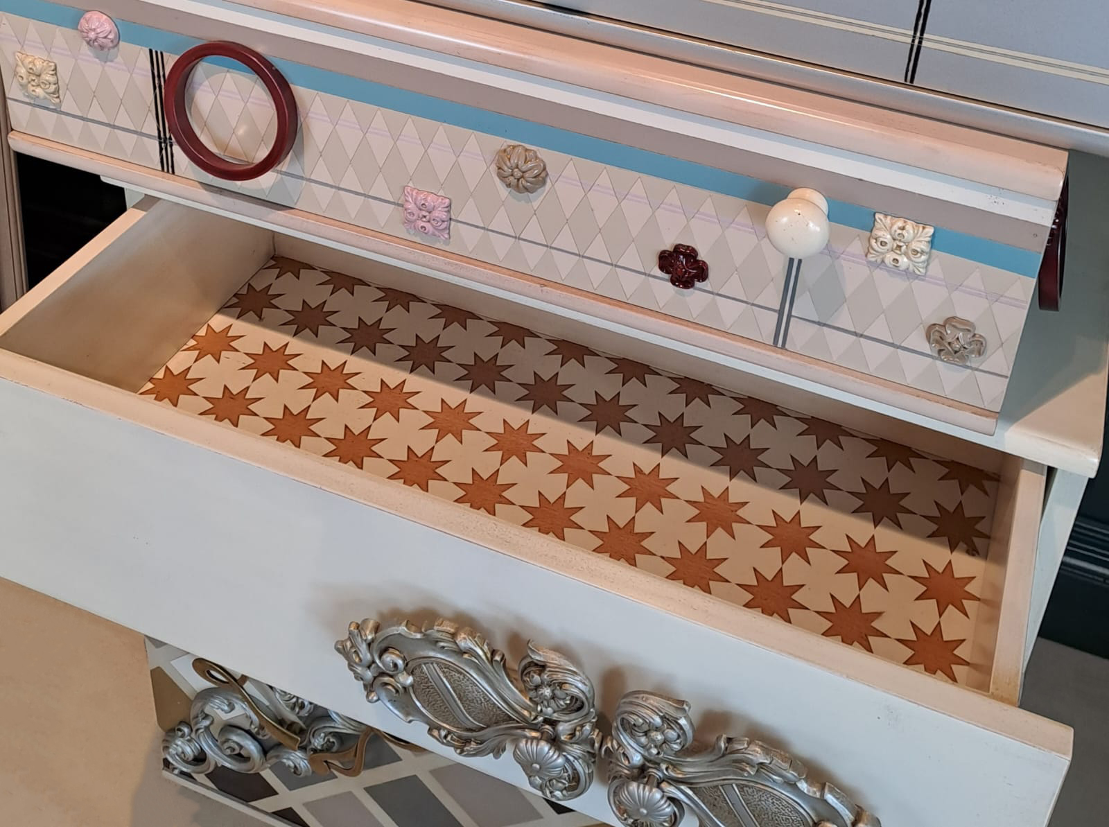 Detalle del Sinfonier Alice con cajón abierto y fondo interior decorado con estampado de estrellas.