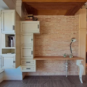 escritorio Trama artesanal instalado en pared de ladrillo con módulos altos