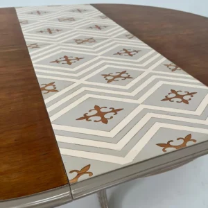 Detalle de la banda geométrica de la mesa de comedor Mudea con dibujo en tonos crema y terracota