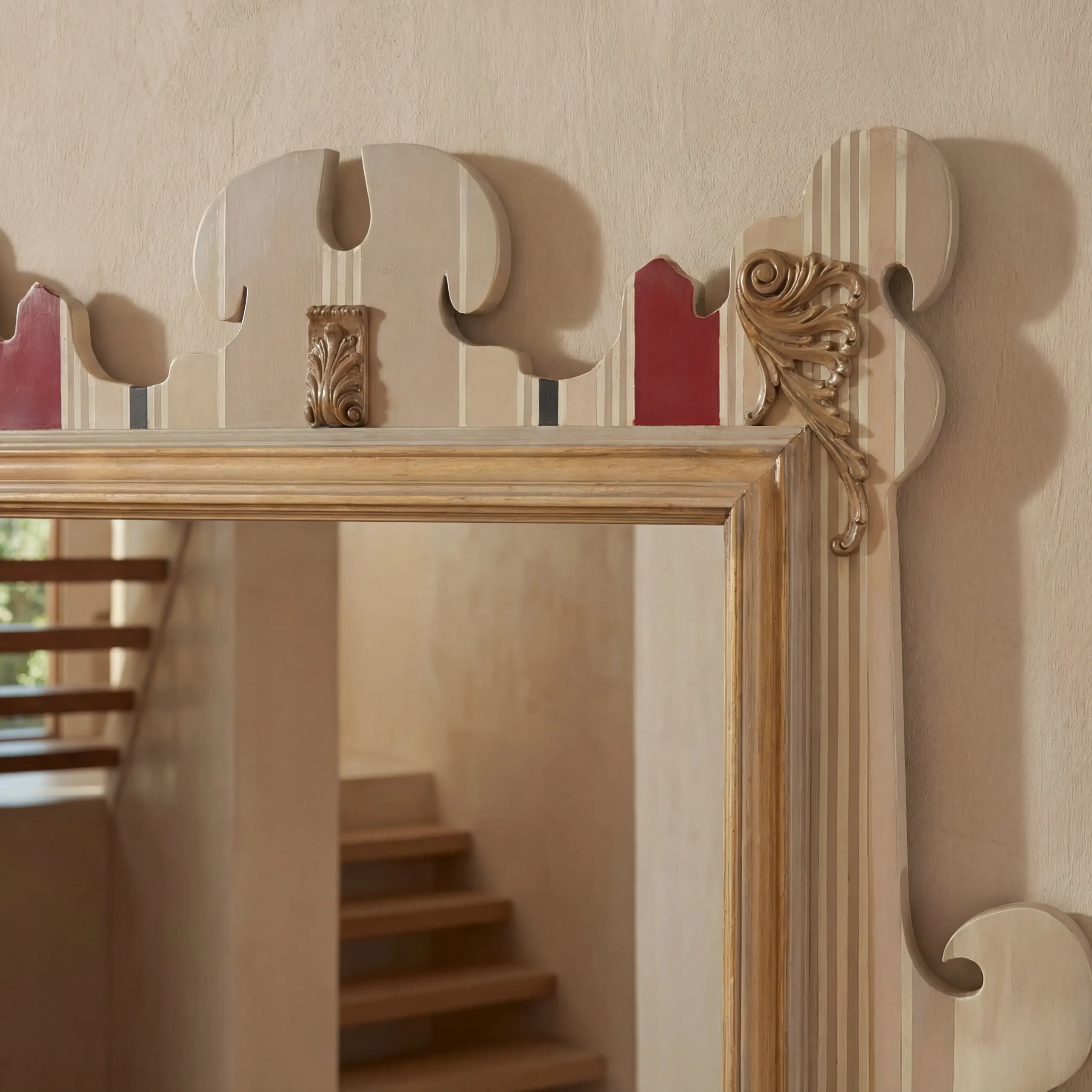 Detalle del diseño único del marco del espejo, combinando un patrón de rayas en tonos beige y acabados en color oro.