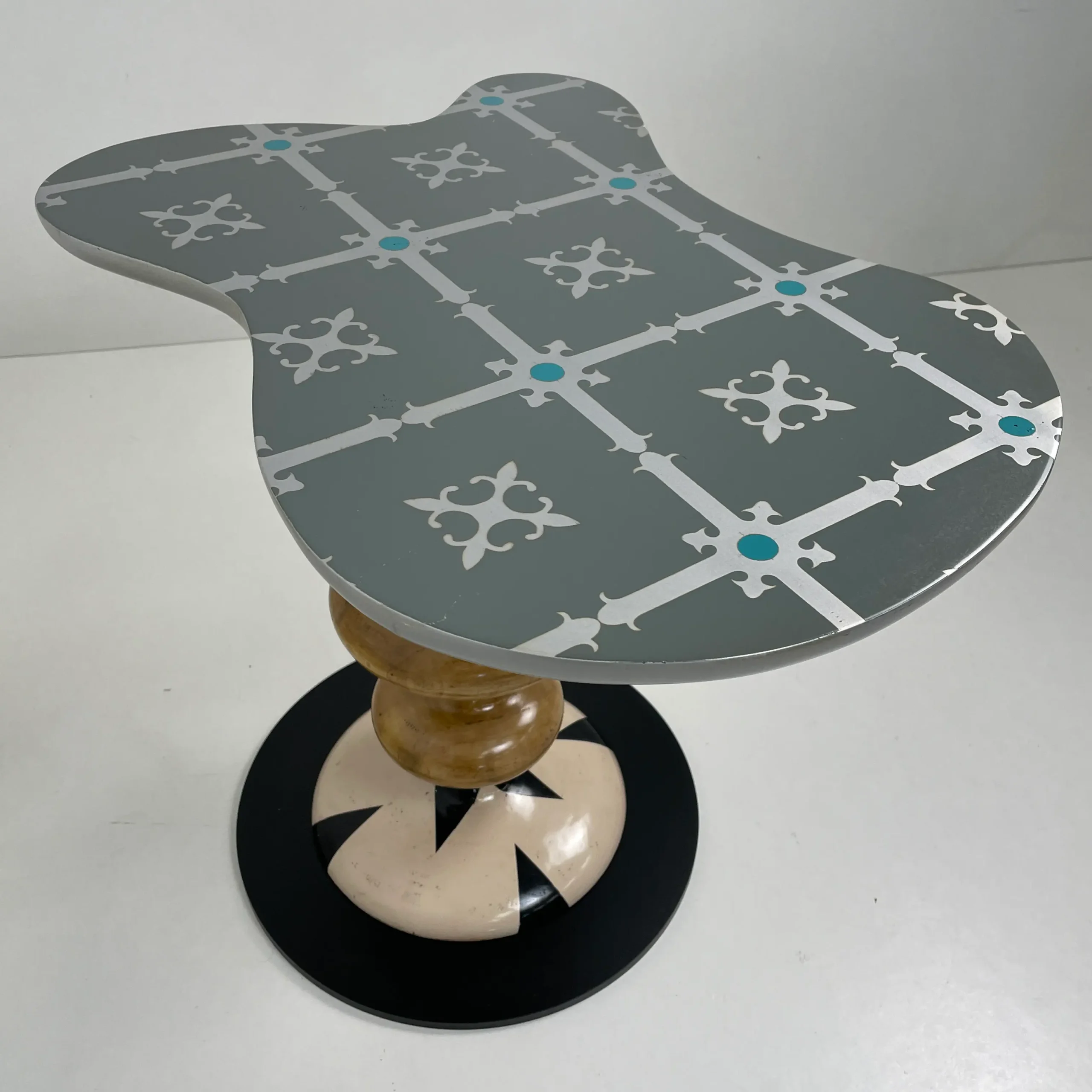 Mesita Marcela: pieza de diseño con silueta curva y detalles gráficos en azul.