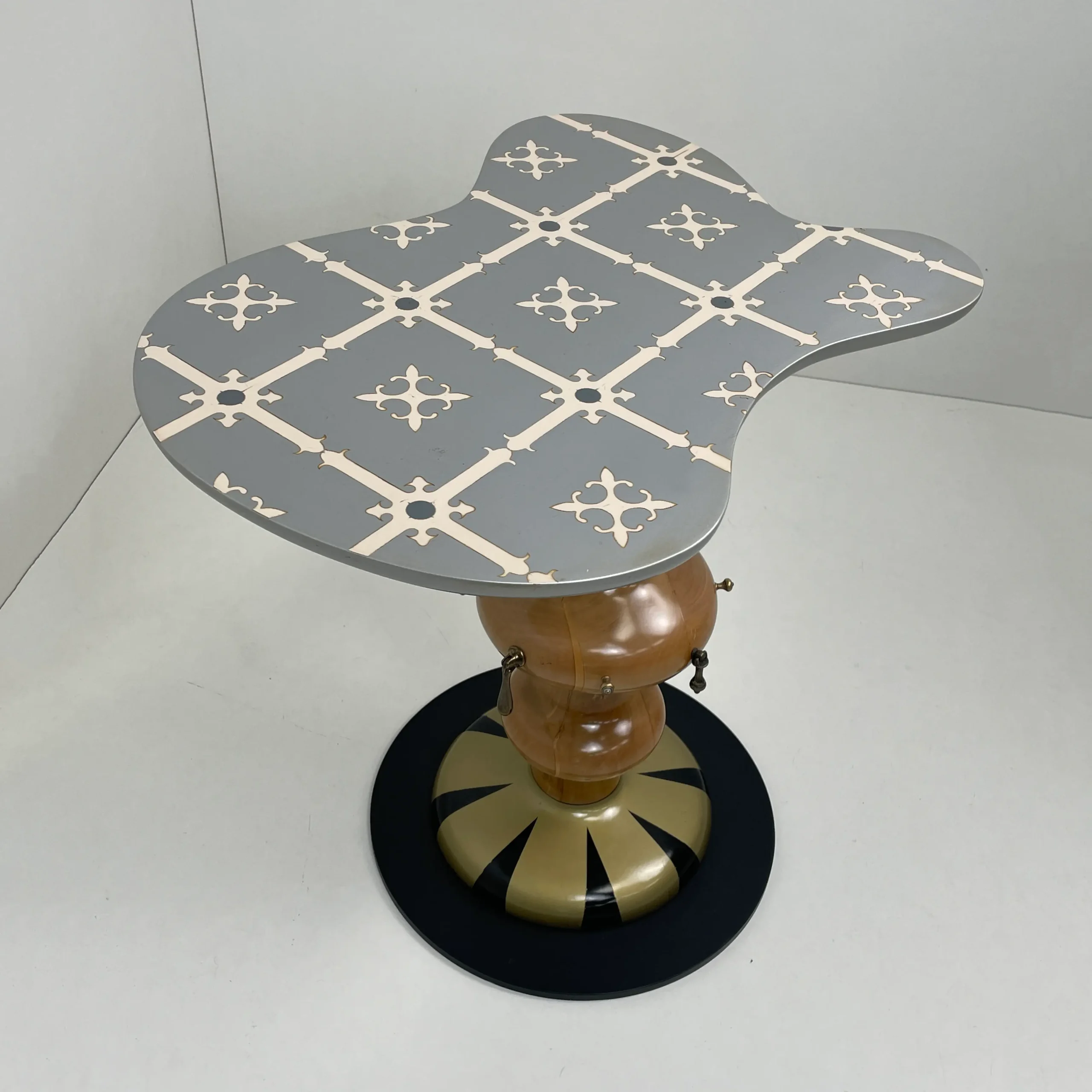 Mesita auxiliar modelo Marcela con tapa de forma orgánica irregular y estampado geométrico.