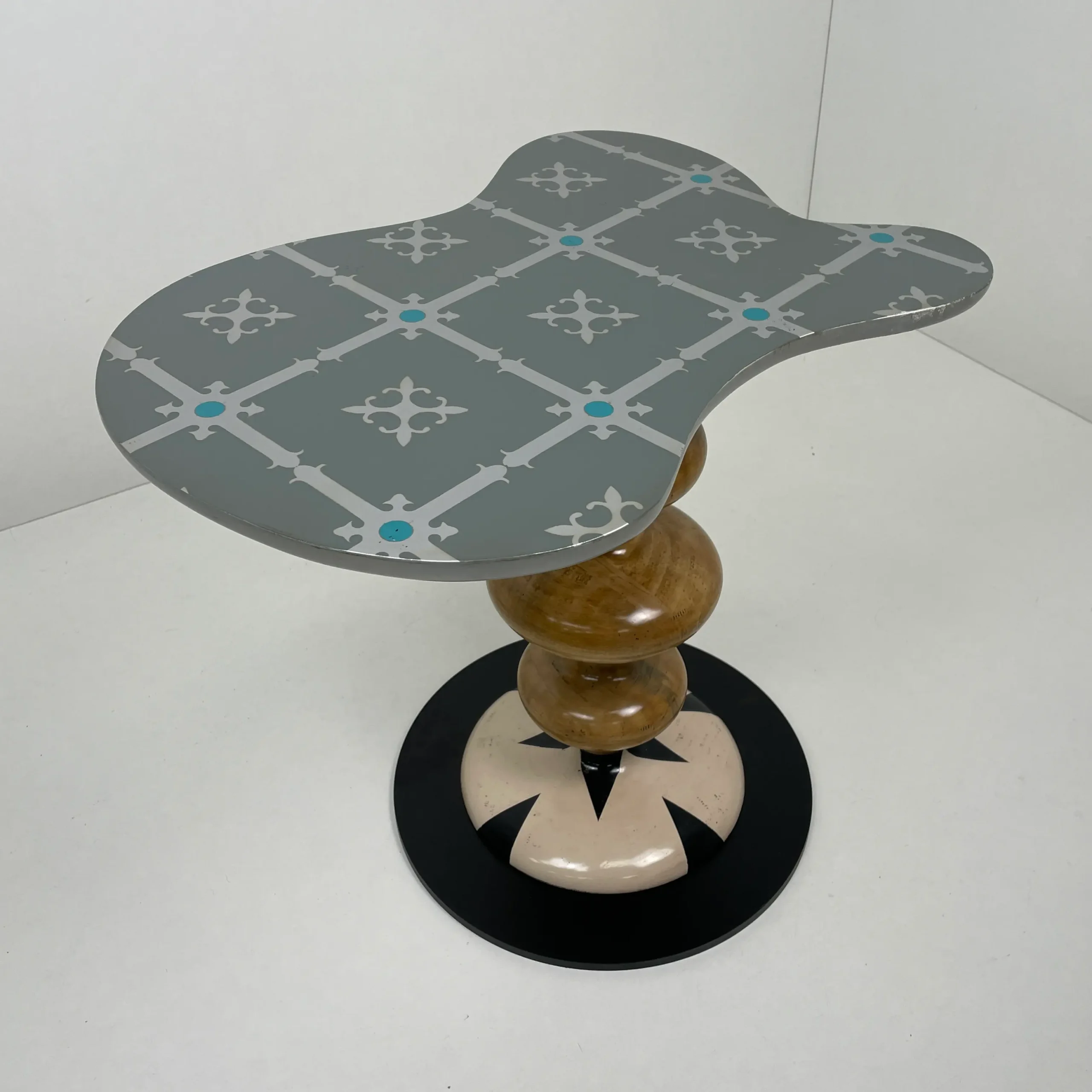 Detalle de la base circular con diseño de estrella en blanco roto y negro.